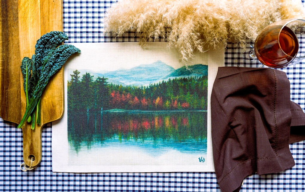 Un'incantevole tovaglietta che rappresenta un laghetto immerso nella natura, dove l'artista Netta Ganor esplora i riflessi delle piante e dell'acqua in una danza di colori delicati.
