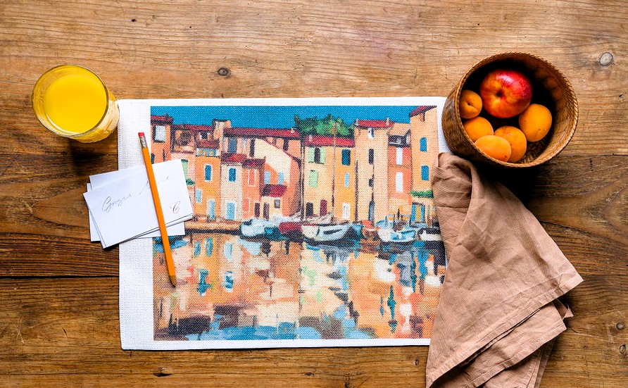 Una tovaglietta che ritrae il porto di Martigues, con il suo paesaggio affascinante e i colori vivaci del mare e dei cieli al tramonto, catturato con maestria da Annalisa Paganini.