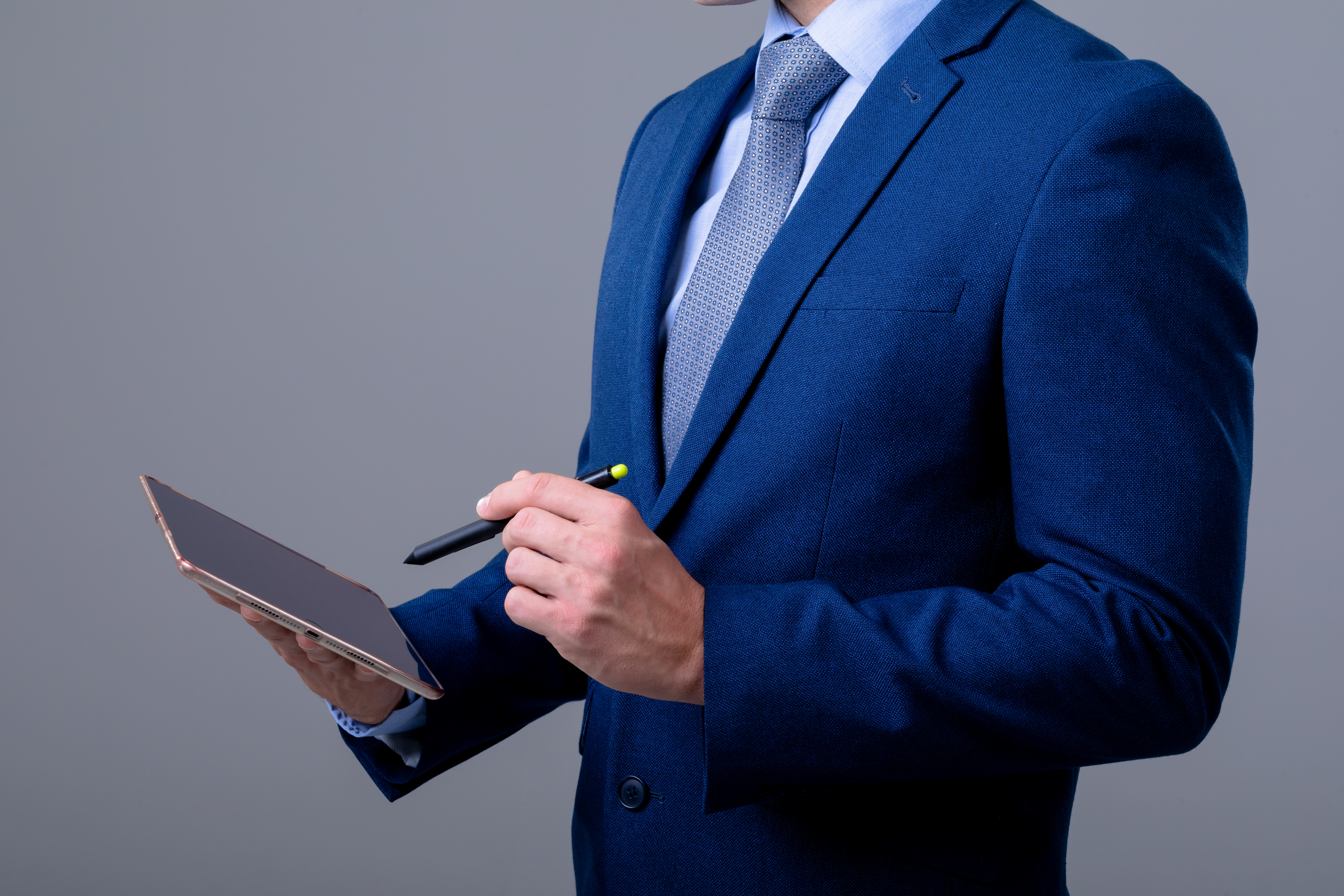 Un uomo in giacca e cravatta blu in un contesto lavorativo.