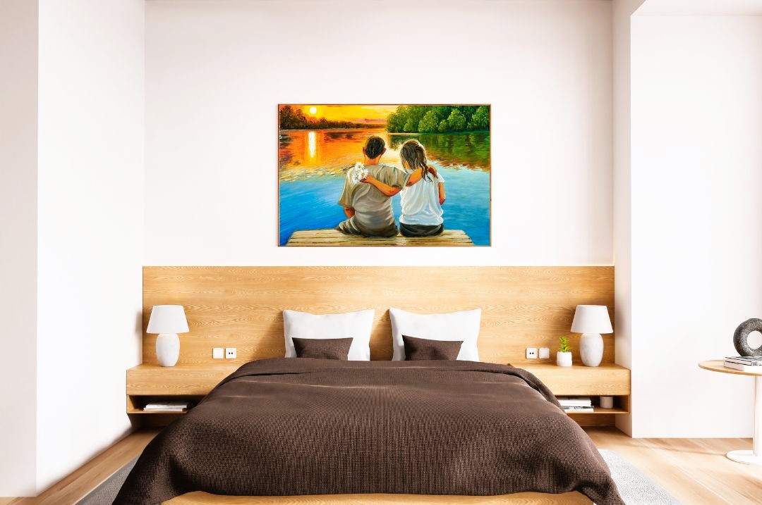 Quadro con una coppia seduta su un pontile di legno, che osserva un vivido tramonto sul lago, appeso sopra il letto in una moderna camera da letto.