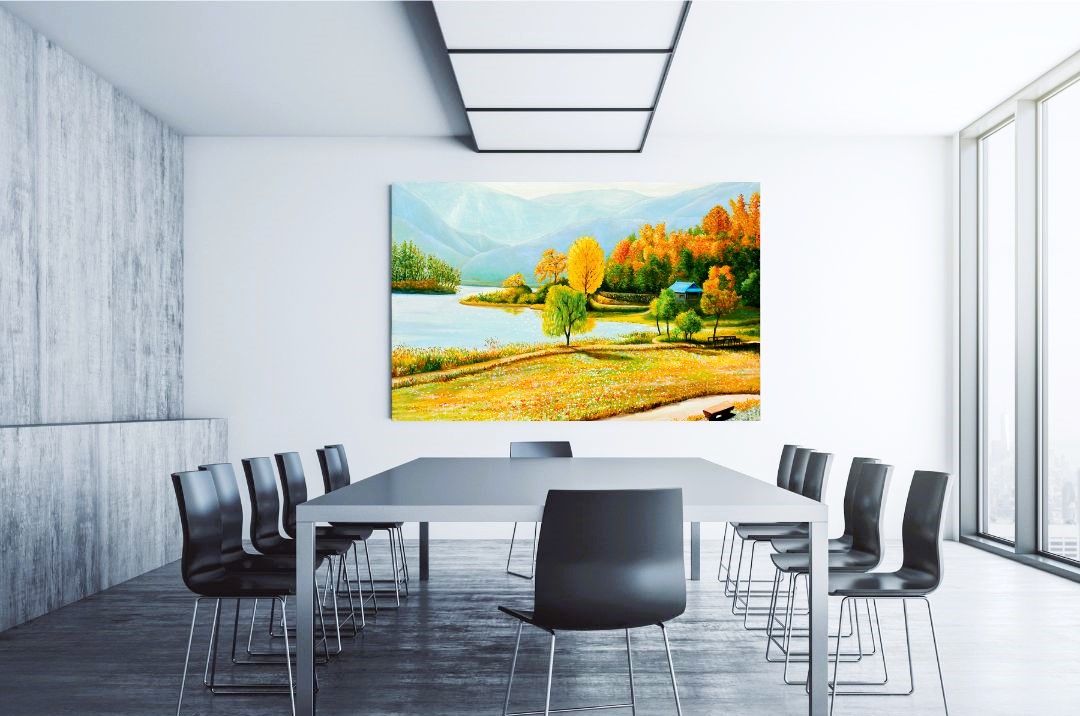 Sala riunioni moderna e spaziosa con un grande quadro paesaggistico raffigurante un lago circondato da alberi con colori autunnali e montagne sullo sfondo, creando un'atmosfera rilassante e ispiratrice per le discussioni.
